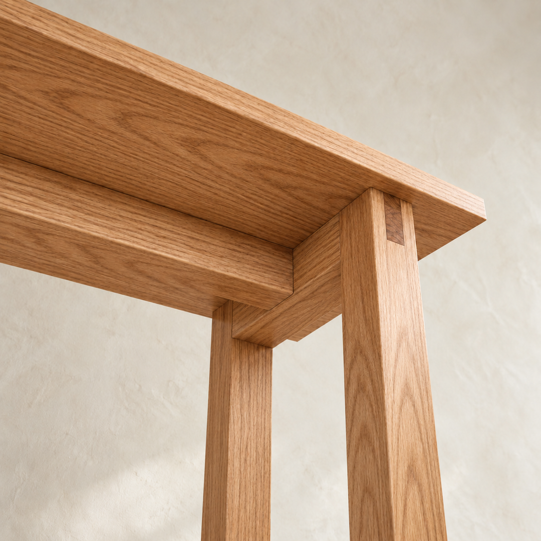 Close-up from below of a corner of the 2 person bar table in red oak, showing the bridle joint at the top of a leg and the rails under the top.