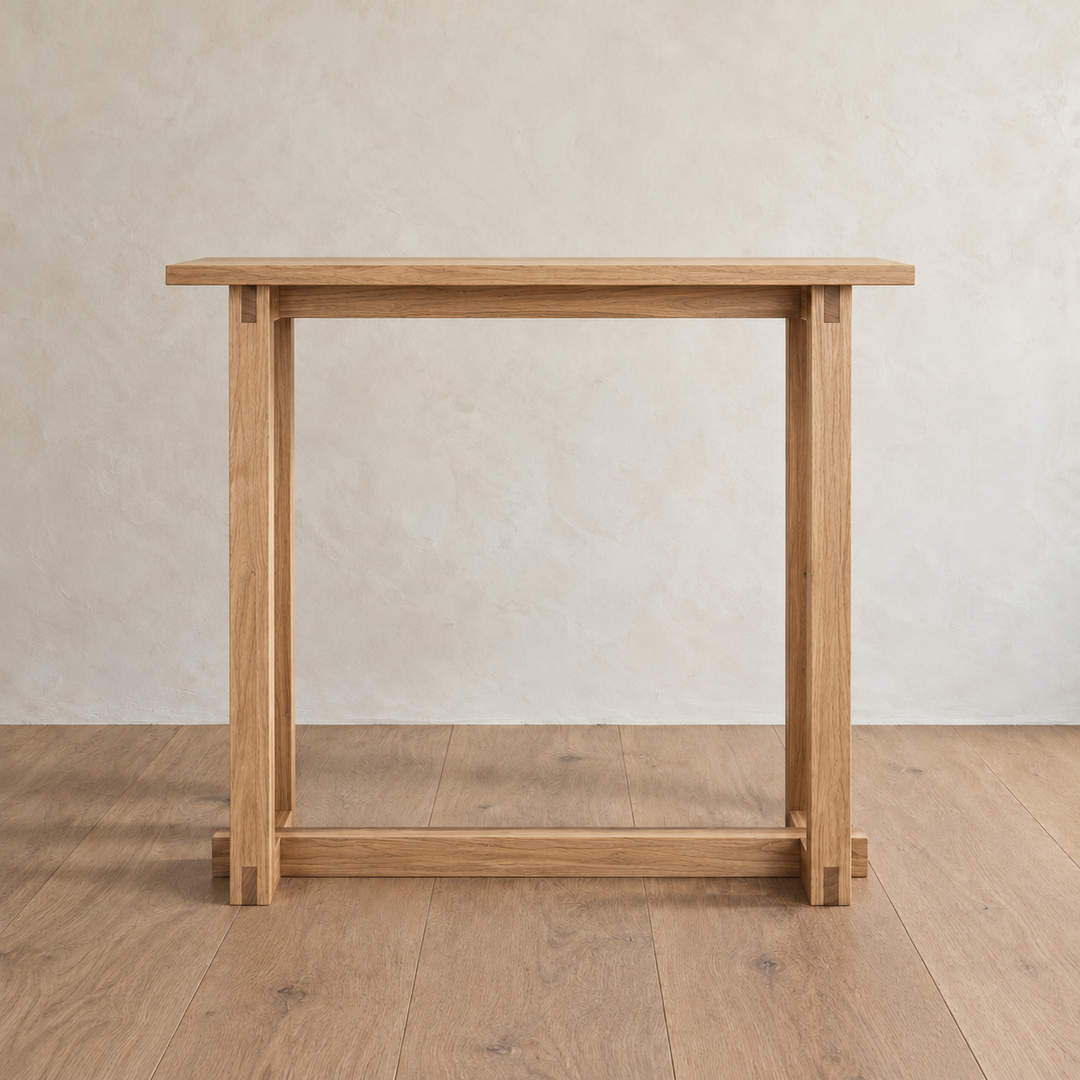 Front view of the 2 person bar table in white oak against a plaster wall, showing the stretcher under the top and the one near the floor.