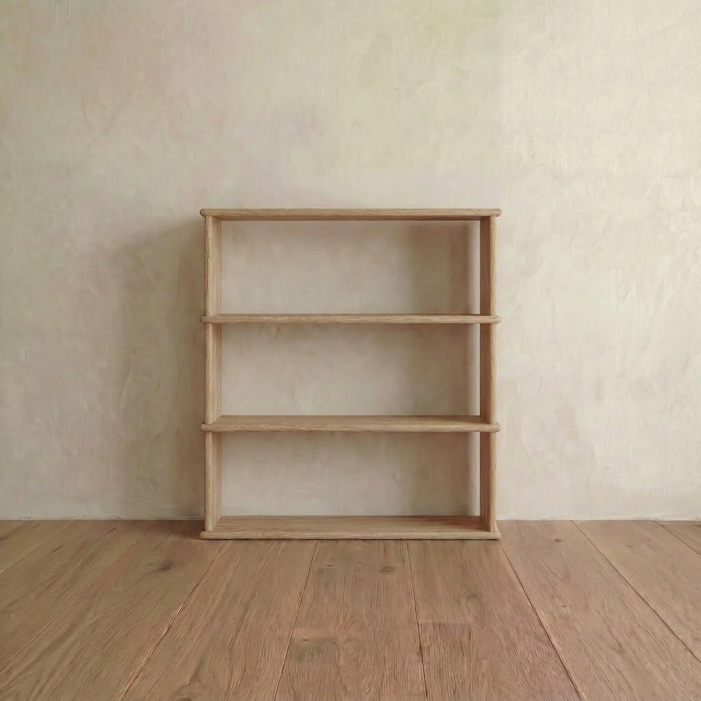 A compact, handmade 3 shelf bookcase in white oak stands empty against a pale wall on a wooden floor—an ideal quality Vancouver furniture piece.