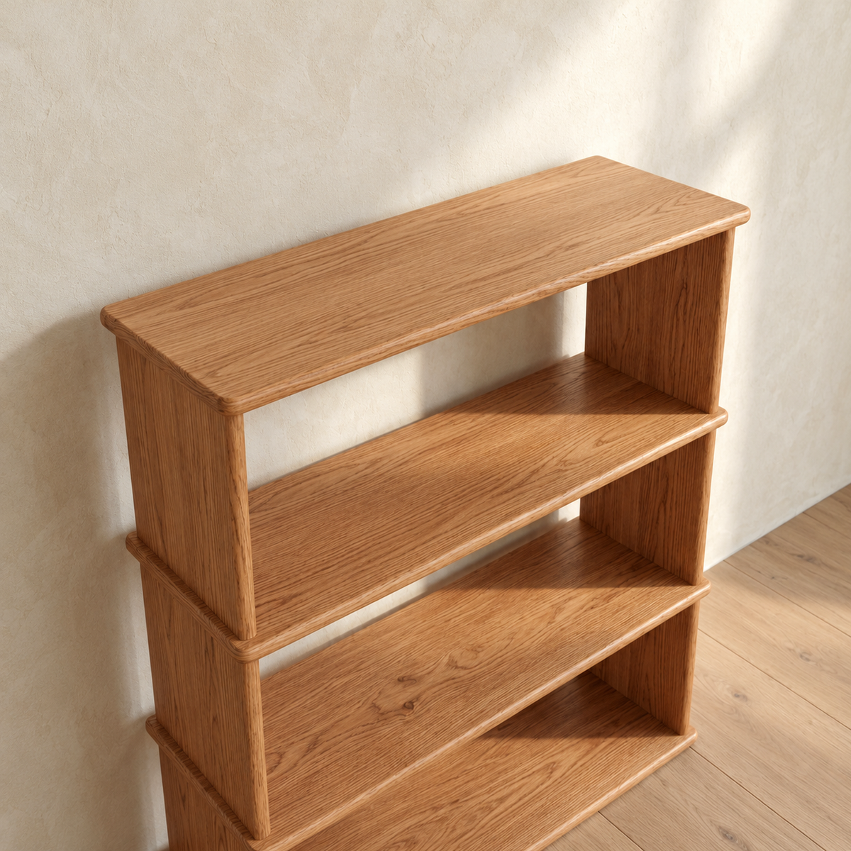 The 3 shelf bookcase in red oak from a high angle, showing the oak grain across the top and shelves and how each shelf extends slightly past the sides.
