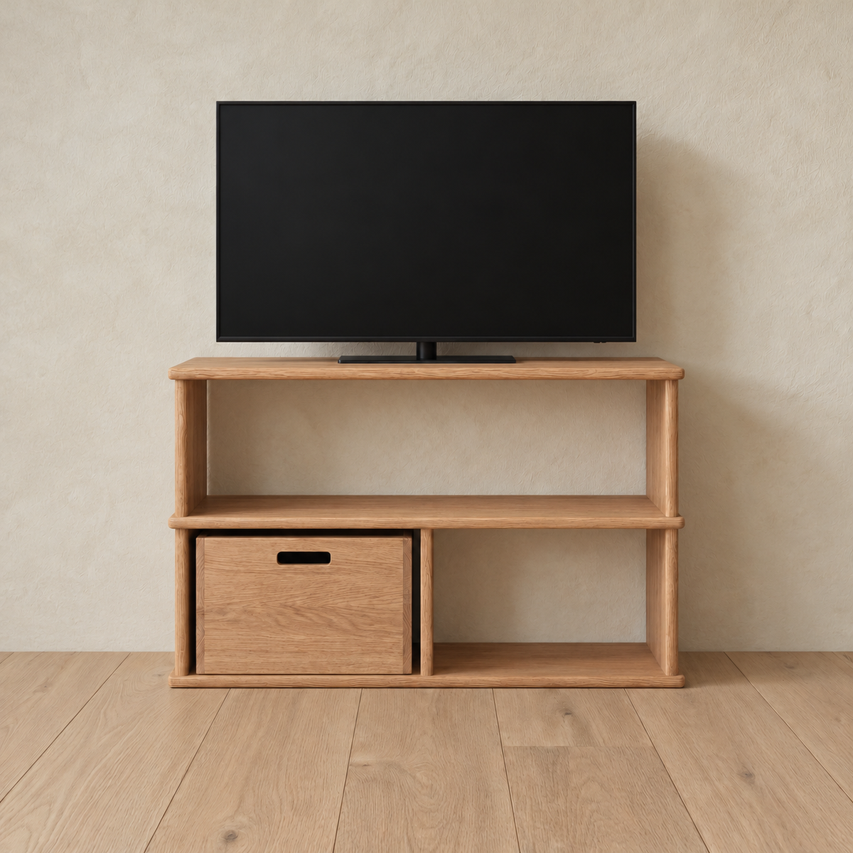 The 40 inch bookshelf TV stand in red oak holding a flat-screen TV, with a wooden storage cube in the lower left opening, against a plaster wall.