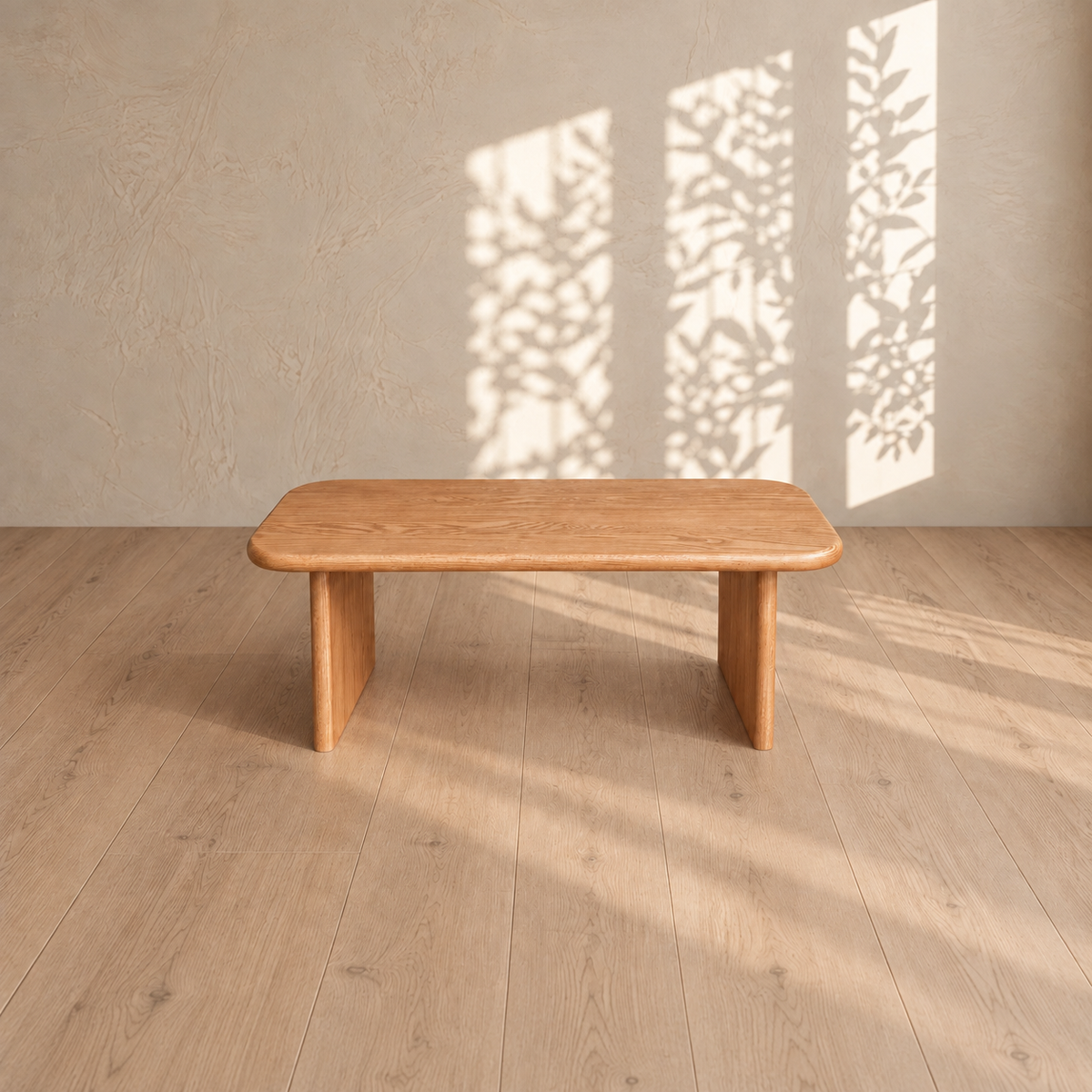 A 40 inch coffee table in red oak on a light wood floor, with leafy window shadows on the plaster wall behind it.