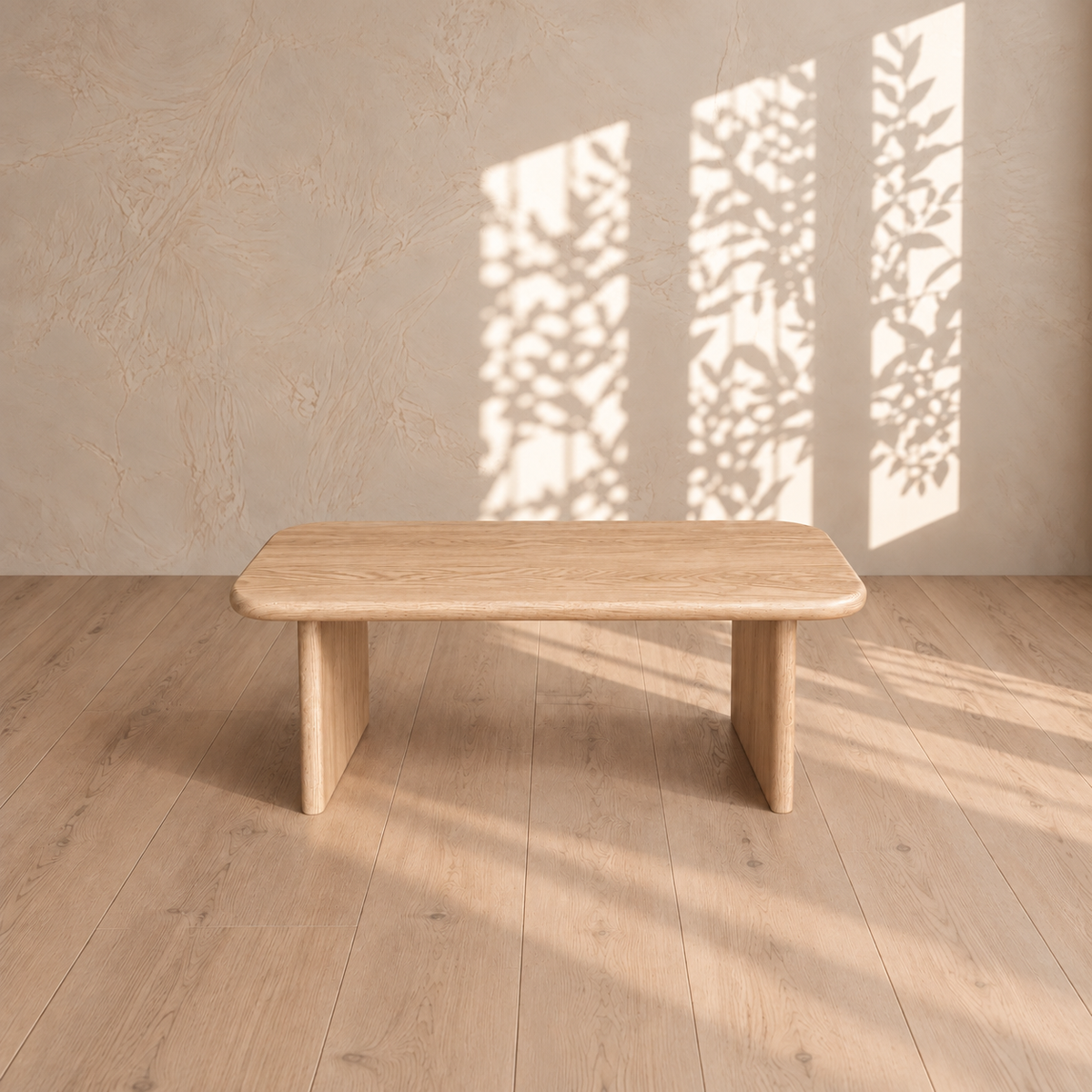 A 40 inch coffee table in white oak on a light wood floor, with leafy window shadows on the plaster wall behind it.