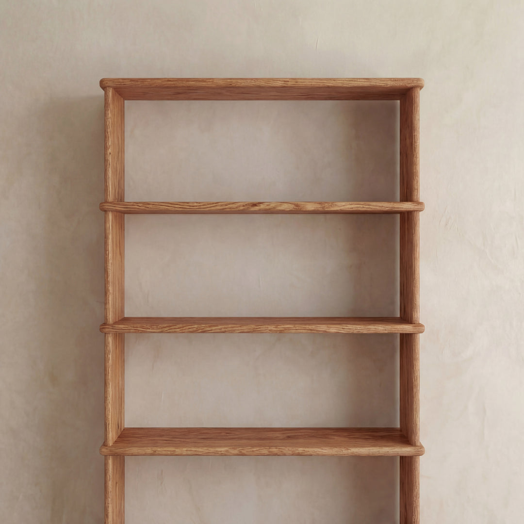 A 5 shelf bookcase in red oak with a smooth finish and minimalist design stands empty against a plain beige wall.