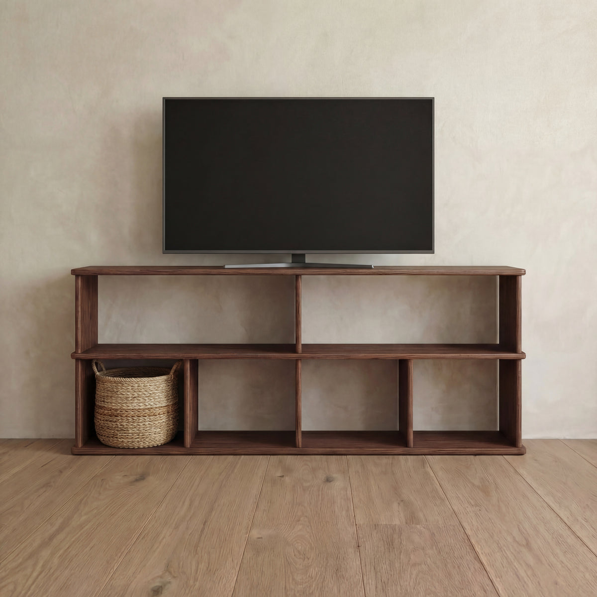 A 65 inch bookshelf TV stand in walnut holding a flat-screen TV, with a woven basket in one of its open cubes.