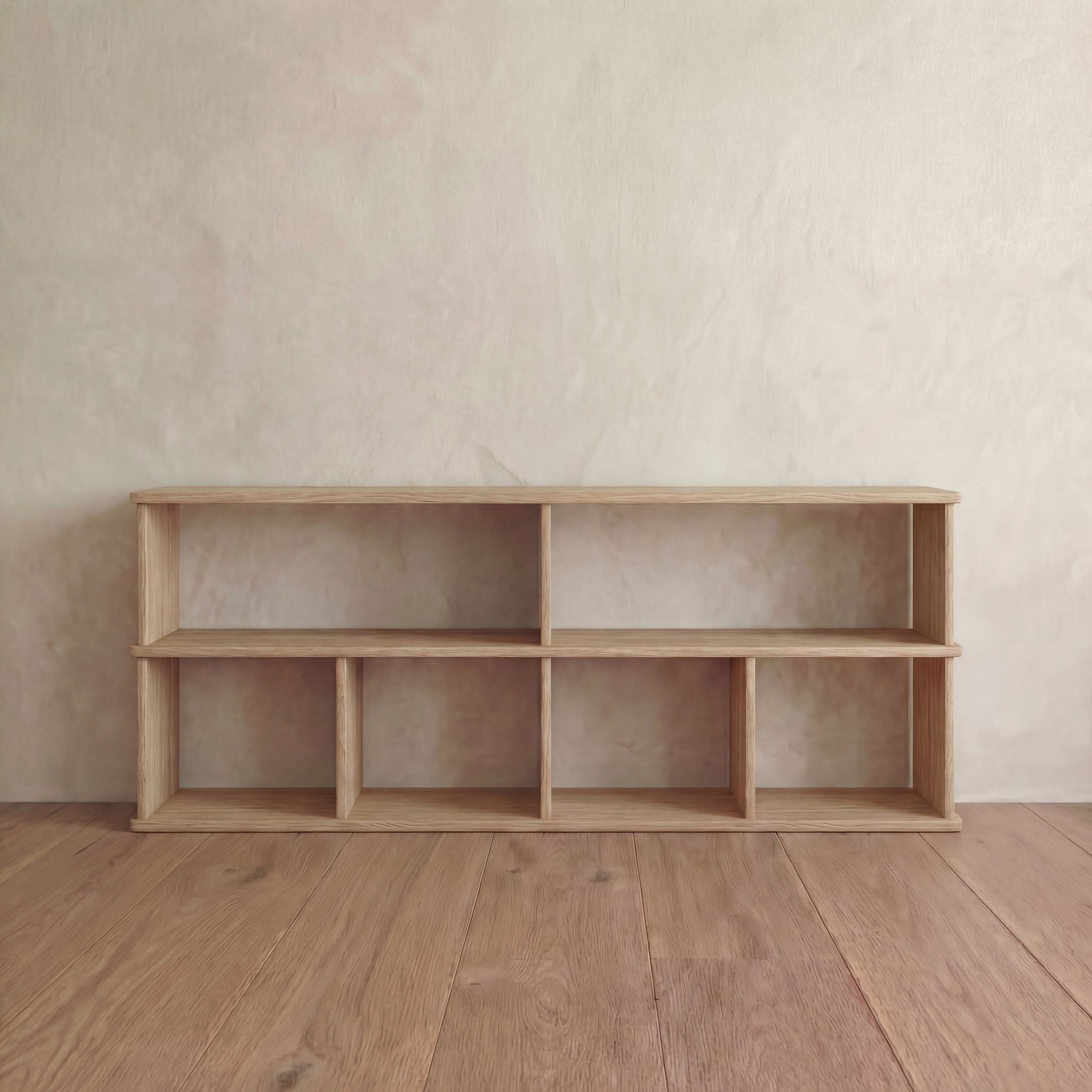 The 65 inch bookshelf TV stand in white oak features six open compartments and stands empty against a light-colored textured wall and wooden floor.