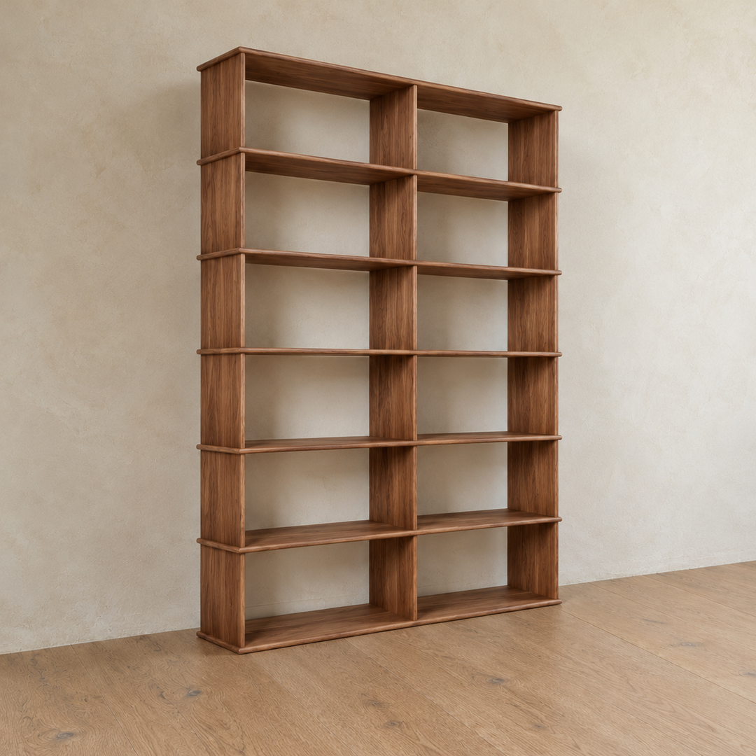 The 2 column 7 foot tall bookcase in walnut from an angle against a plaster wall.