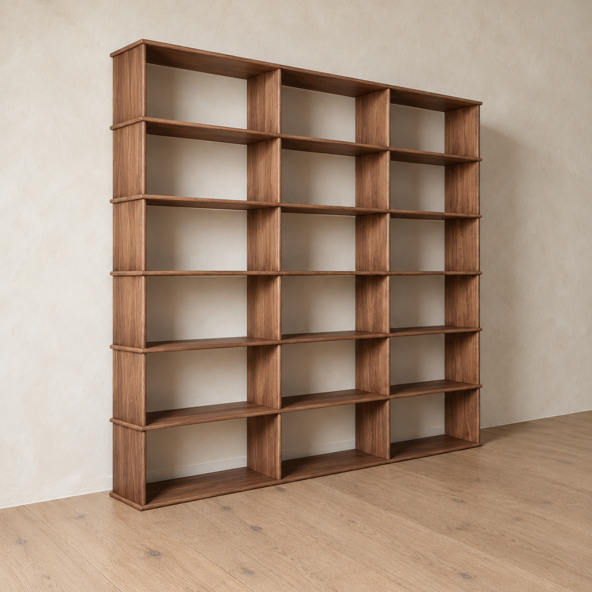 The 3 column 7 foot tall bookcase in walnut from an angle against a plaster wall.