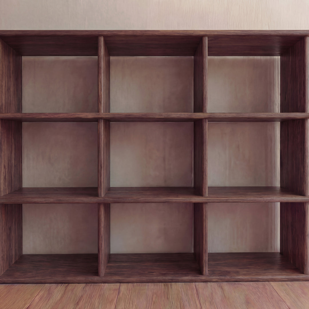 A large, handmade Nine Cube Bookshelf in walnut stands against a plain, light-colored wall on a wooden floor.