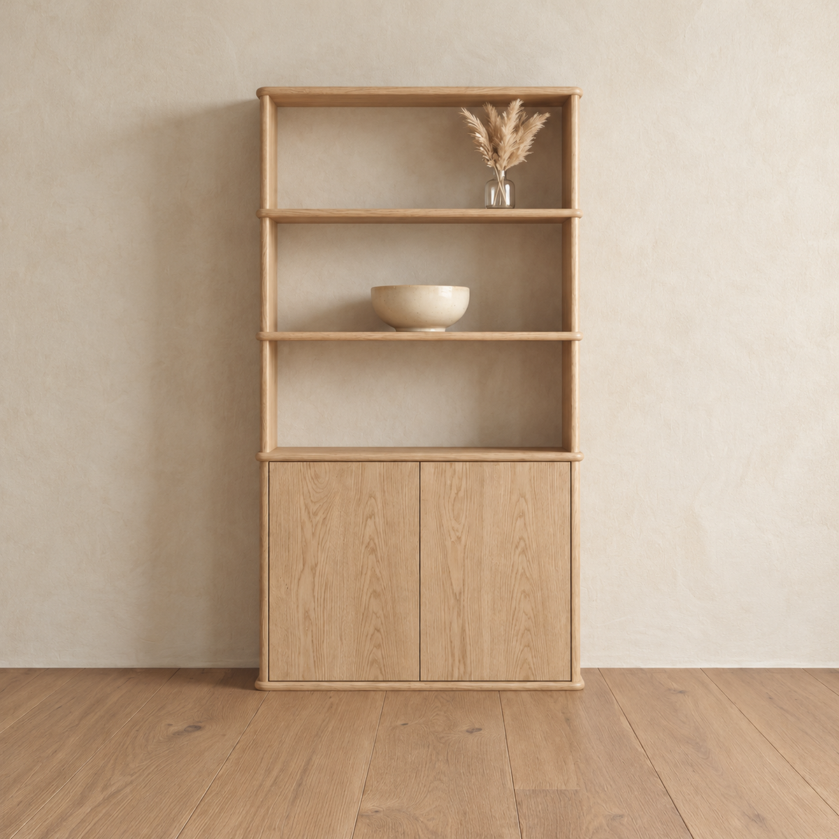 The cabinet bookshelf in white oak against a plaster wall, with three open shelves above a two-door cabinet, holding a small vase of dried grass and a bowl.
