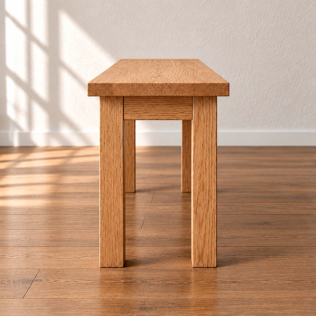 End view of the farmhouse bench in red oak, showing two square legs and the apron joined just below the top.