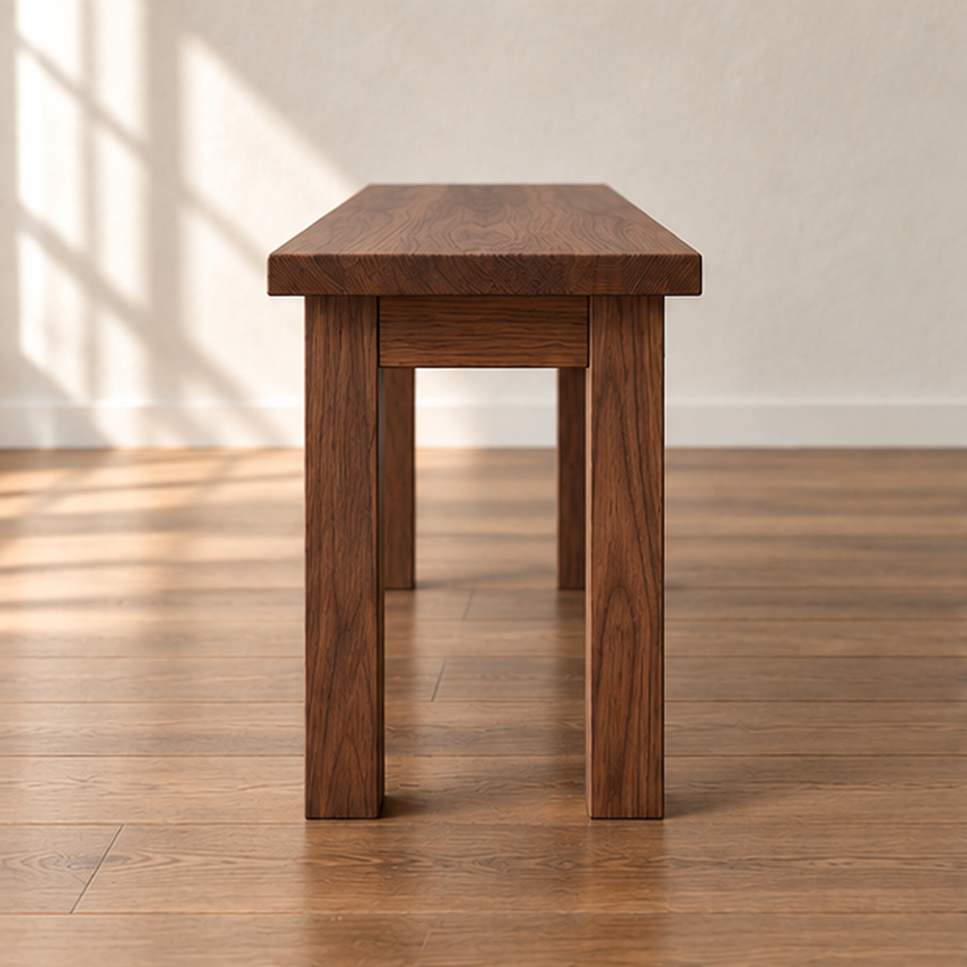 End view of the farmhouse bench in walnut, showing two square legs and the apron joined just below the top.