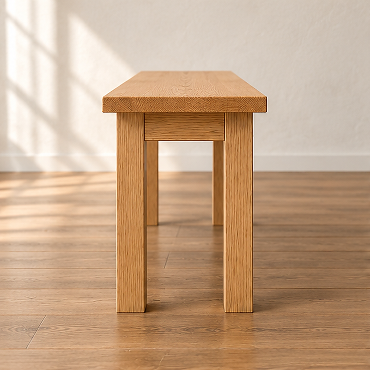 End view of the farmhouse bench in white oak, showing two square legs and the apron joined just below the top.