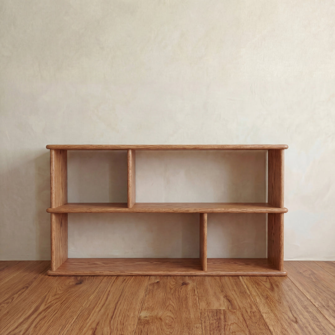 Handmade in Vancouver, the Horizontal bookshelf in red oak features two shelves and four open compartments. Its minimalist design and natural wood finish make it a stylish, functional addition to any room.