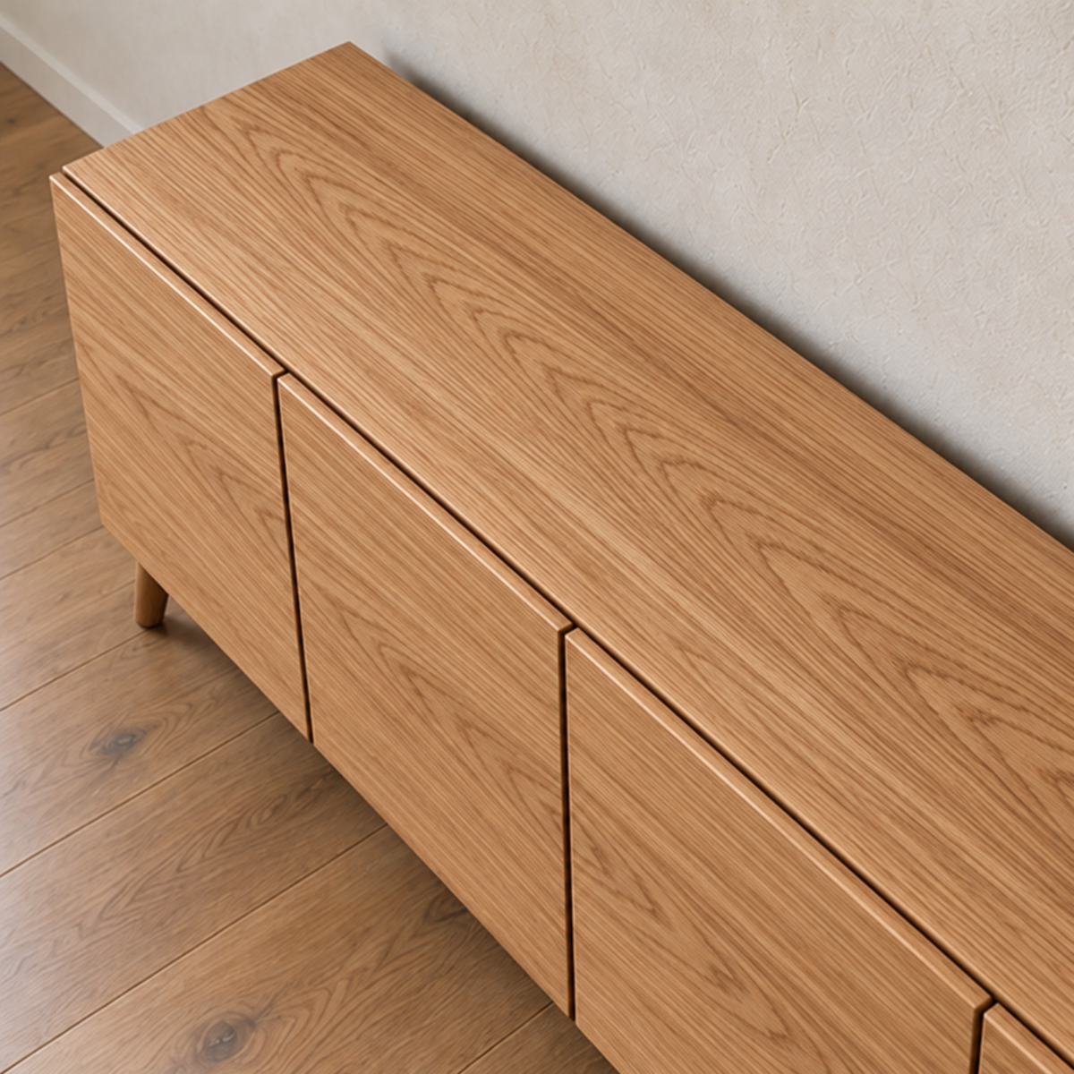 The media console in red oak seen from above, showing the grain across the top and the narrow gaps between the doors.