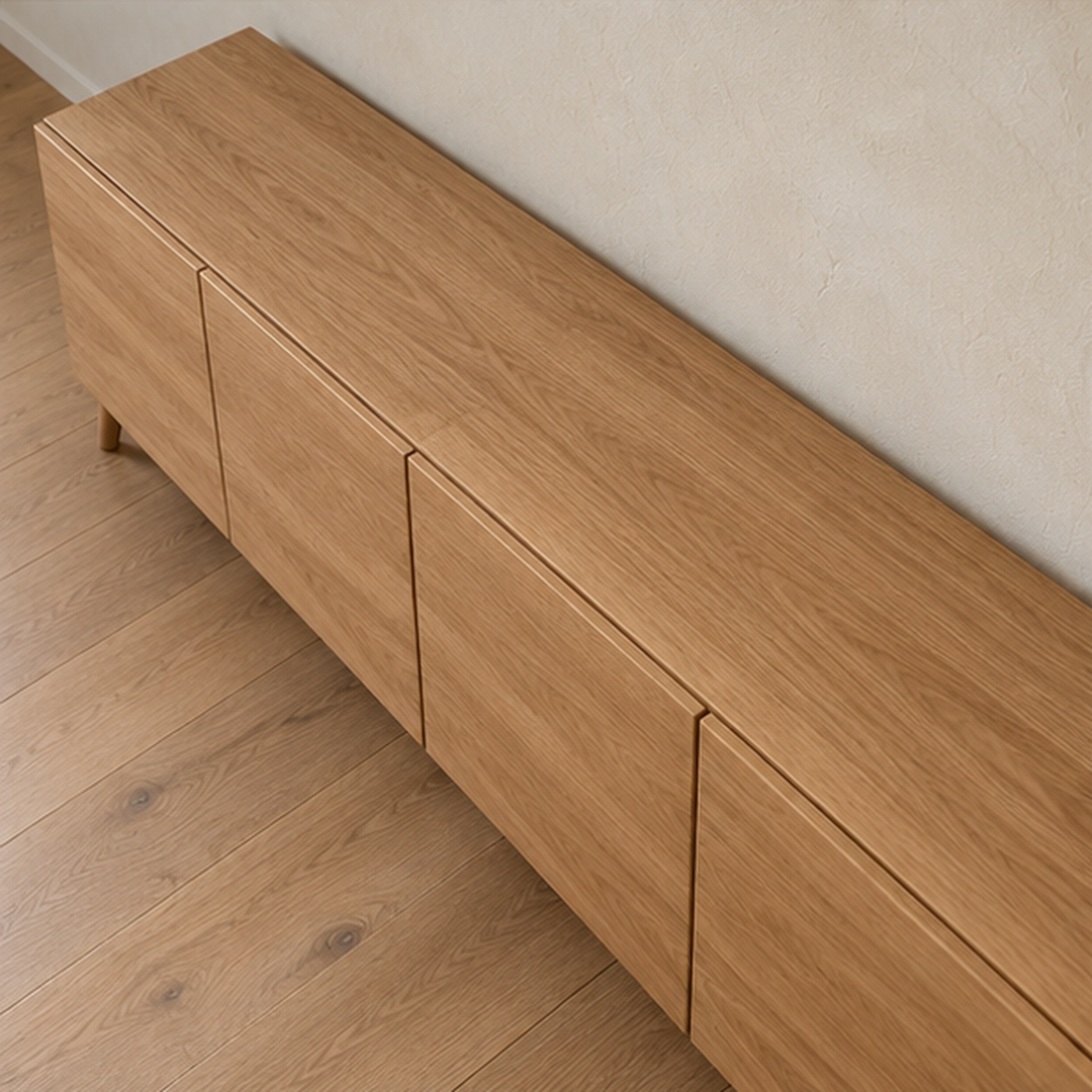 The media console in white oak seen from above, showing the grain across the top and the narrow gaps between the doors.