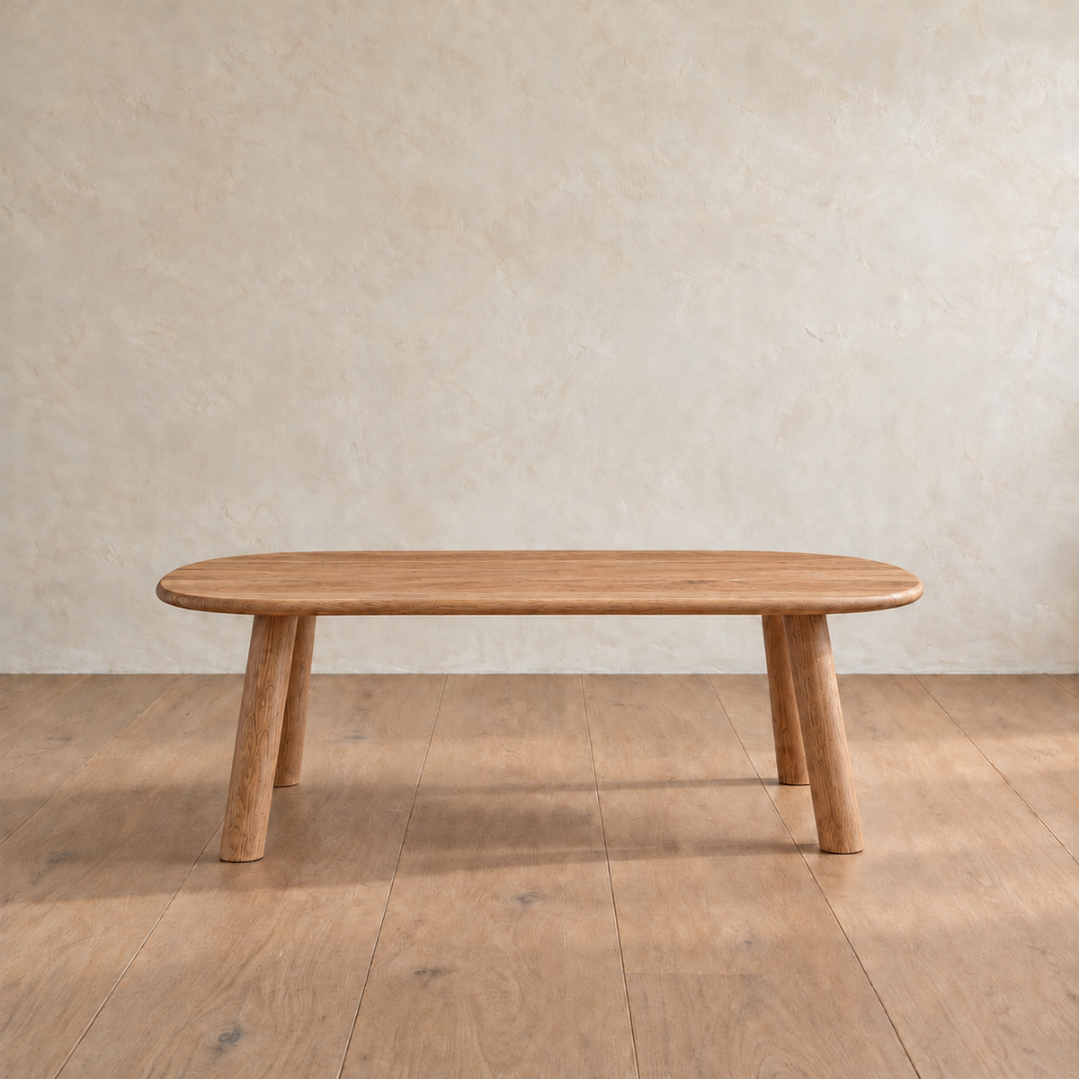 Front view of the minimalist coffee table in red oak, showing the slim top and splayed round legs.