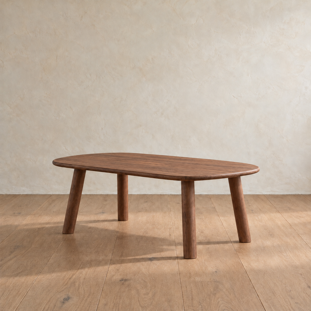 The minimalist coffee table in walnut from the other side, with its four round legs splayed out slightly.