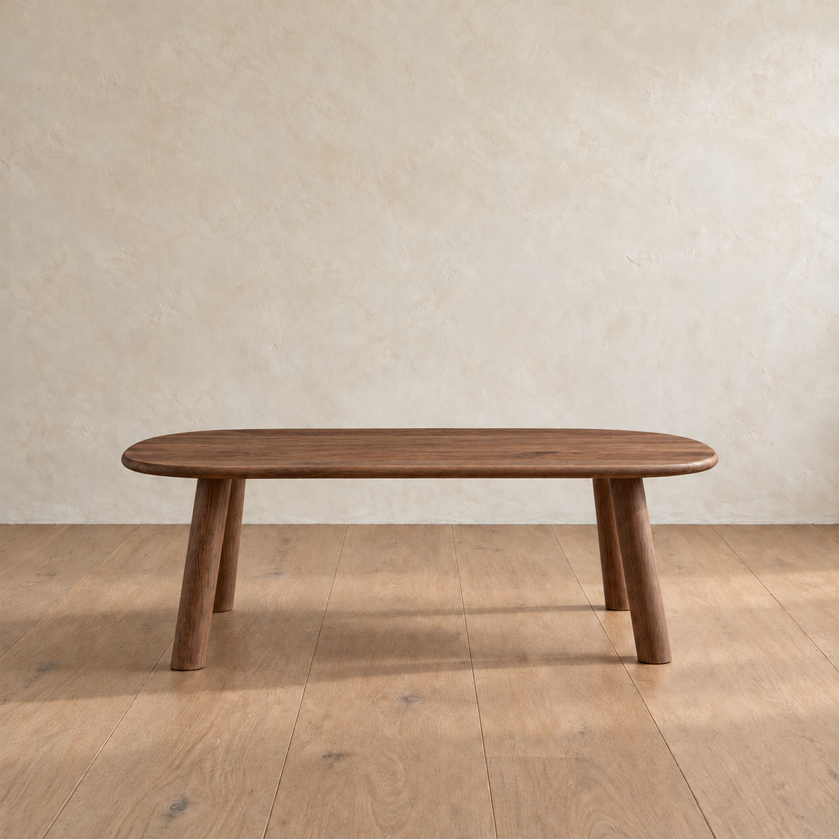 Front view of the minimalist coffee table in walnut, showing the slim top and splayed round legs.