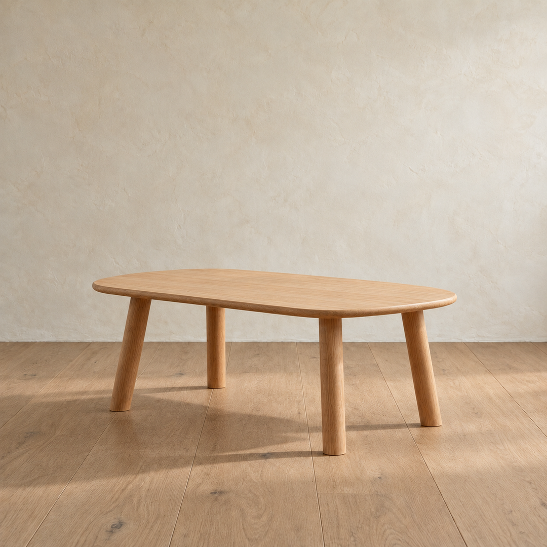 The minimalist coffee table in white oak from the other side, with its four round legs splayed out slightly.