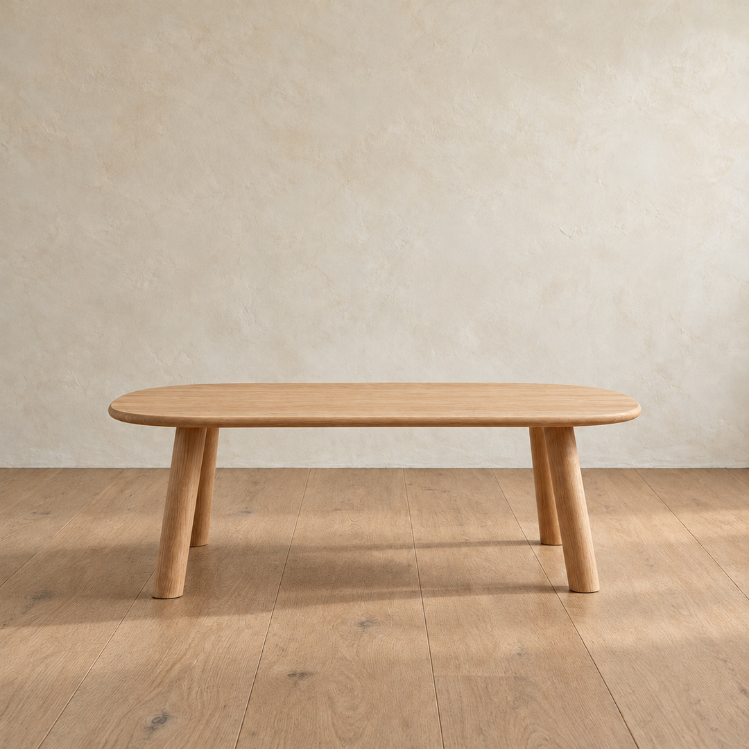 Front view of the minimalist coffee table in white oak, showing the slim top and splayed round legs.
