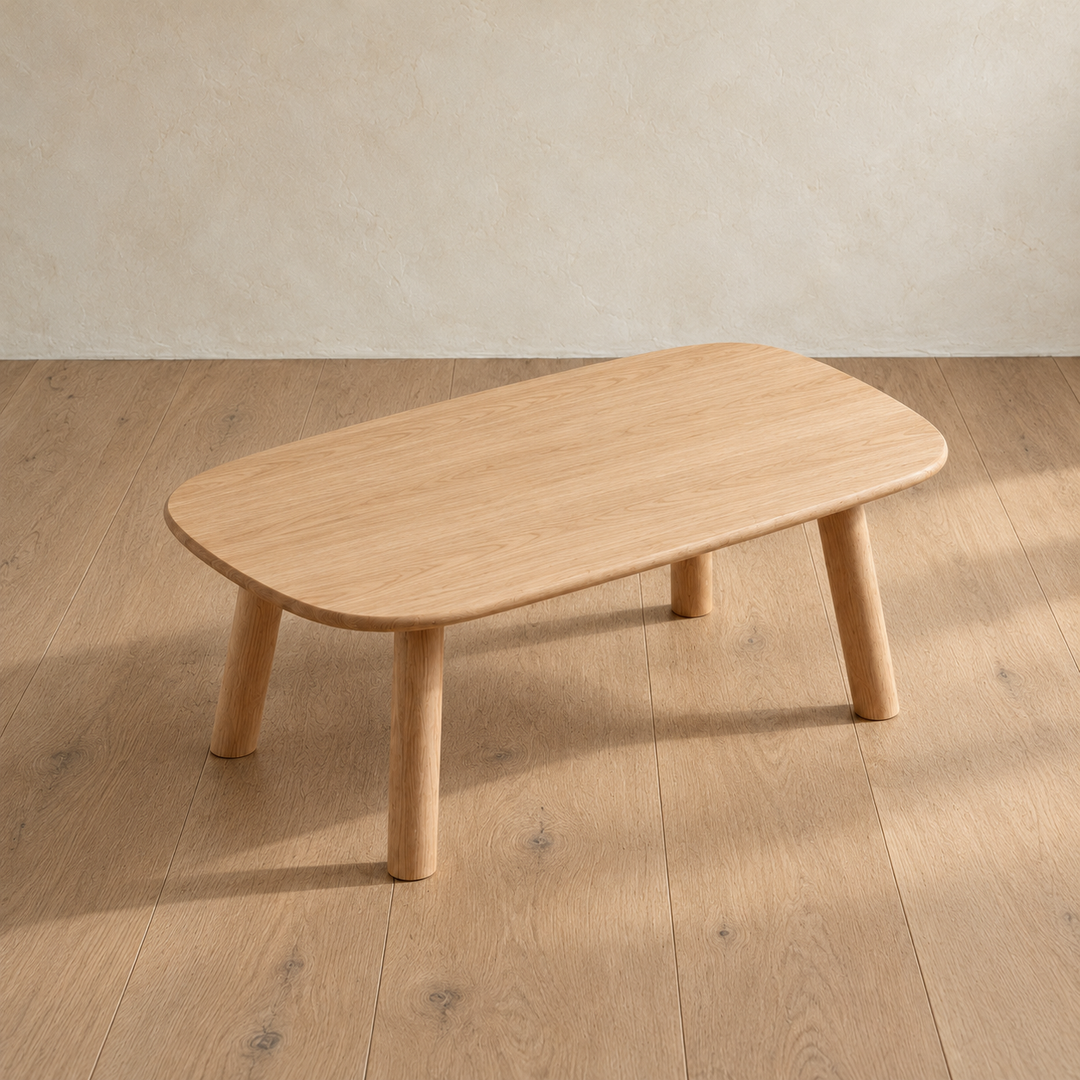 The minimalist coffee table in white oak seen from above at an angle, showing the grain across the top and its rounded corners.