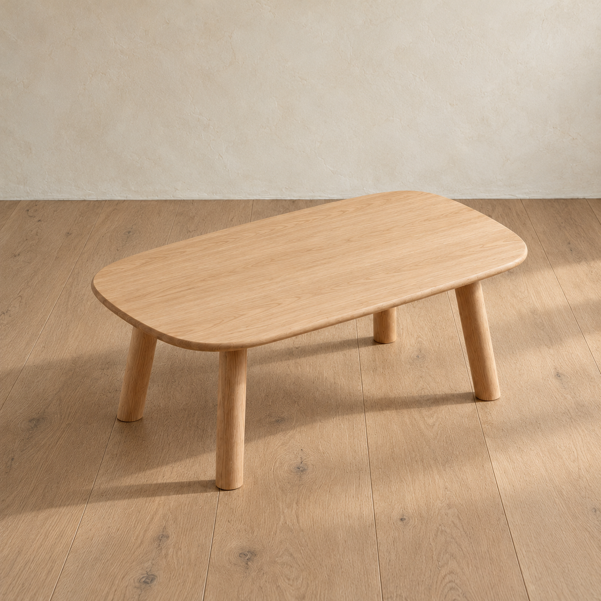The minimalist coffee table in white oak seen from above at an angle, showing the grain across the top and its rounded corners.