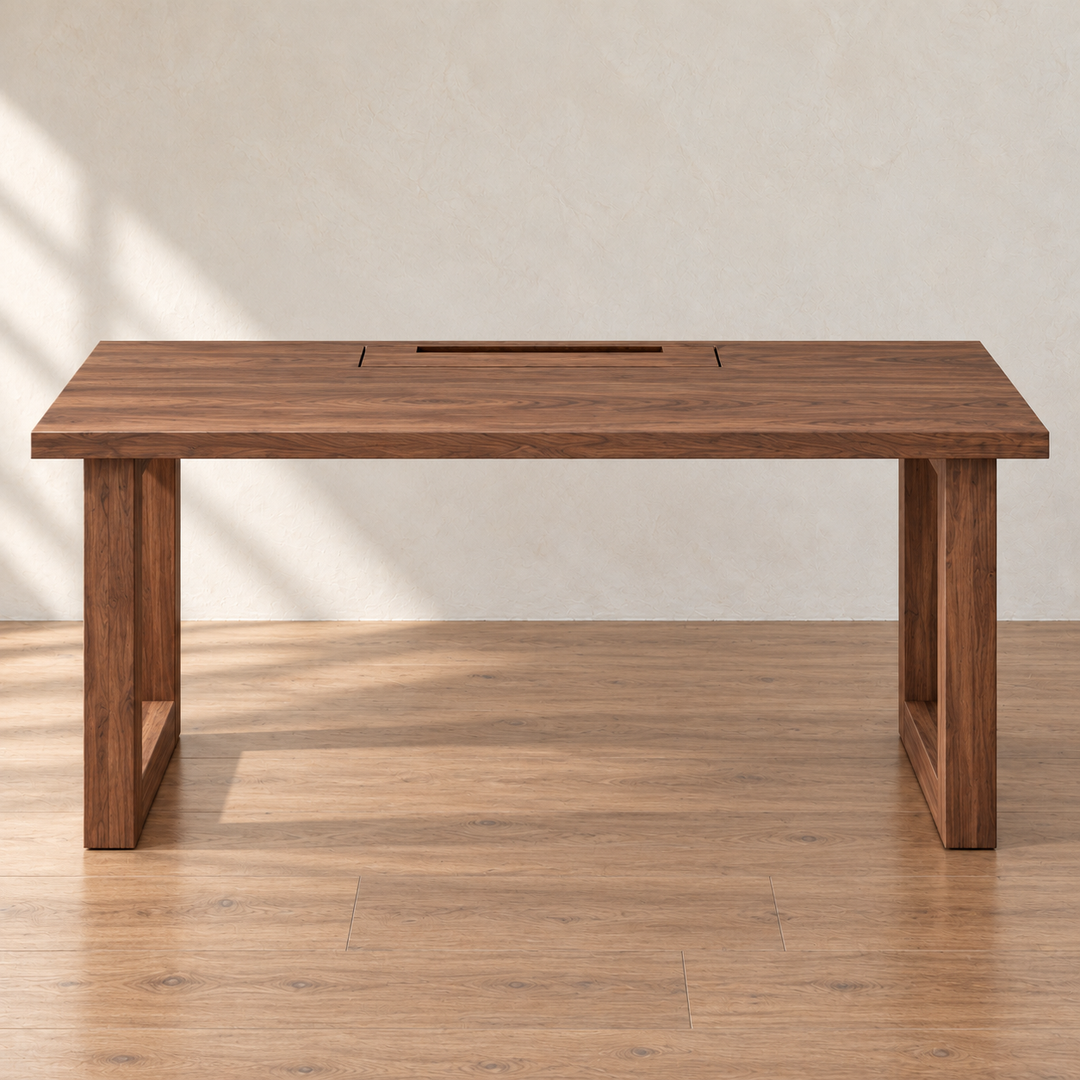 Front view of the minimalist office desk in walnut, with rectangular frame legs and the cable box lid set into the back of the top, in a sunlit room.