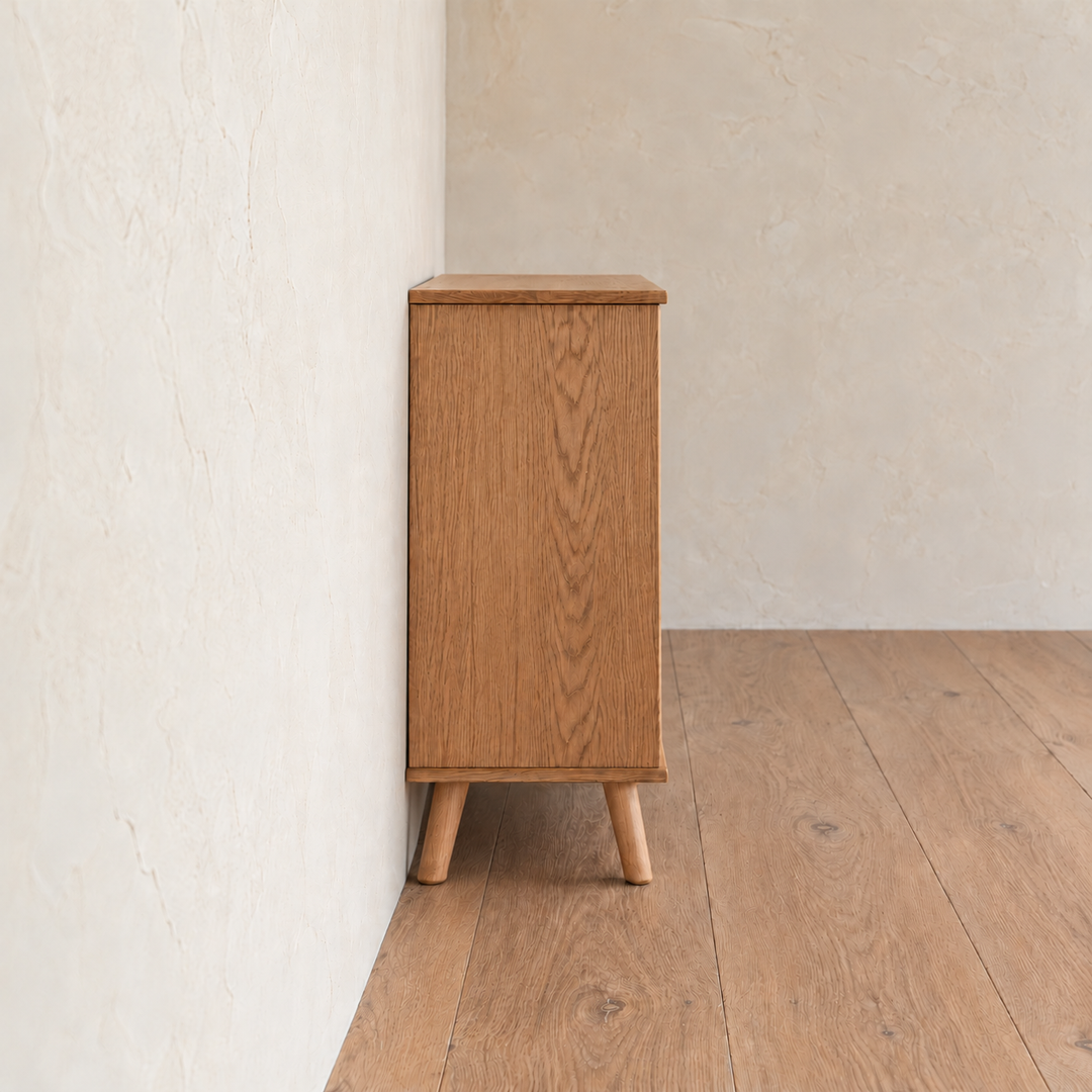 Side view of the rattan cabinet in red oak, showing the solid red oak side panel and splayed tapered legs.