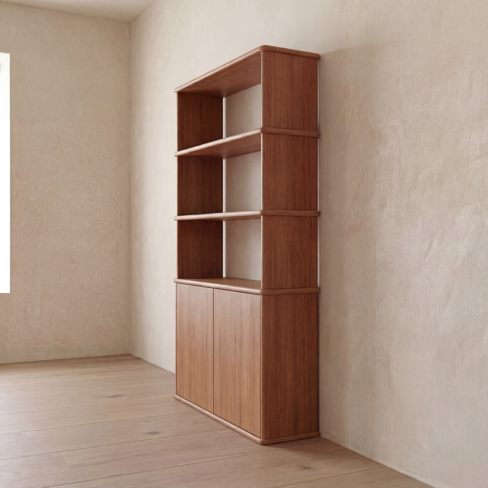 The Cabinet bookshelf in red oak, featuring three open shelves and a closed cabinet with push-to-open doors, stands against a beige textured wall in a minimalistic, sunlit Vancouver room with wooden floors.