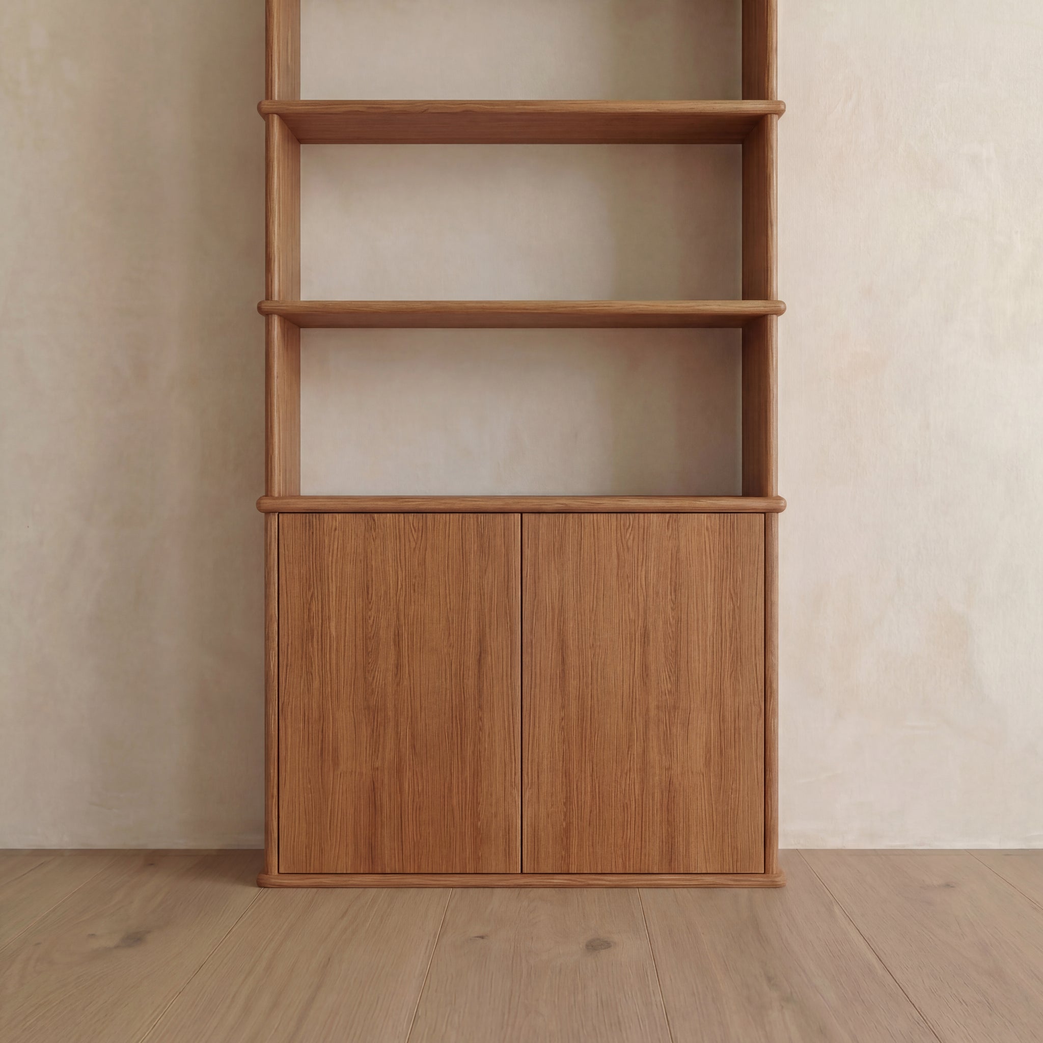 The Cabinet bookshelf in red oak, featuring three open shelves above and a two-door push-to-open cabinet below, stands elegantly against a light-colored wall and wooden floor, adding both style and functionality to any Vancouver home.