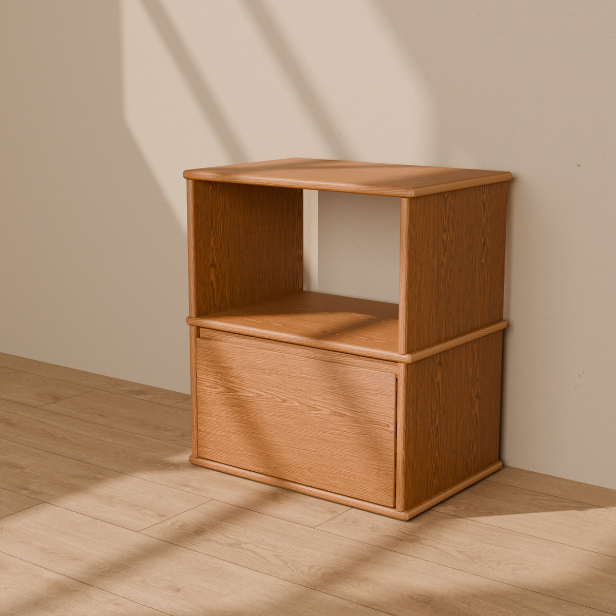 A solid wood nightstand in red oak with an open shelf above a single drawer and softly rounded edges, against a plain plaster wall.