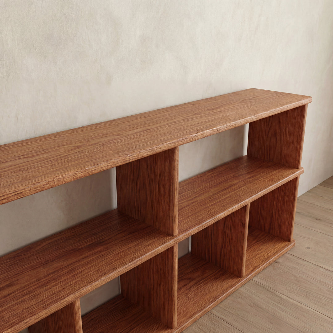 A 65 inch bookshelf TV stand in red oak with two levels and six open compartments, positioned against a light-colored wall on a wooden floor.
