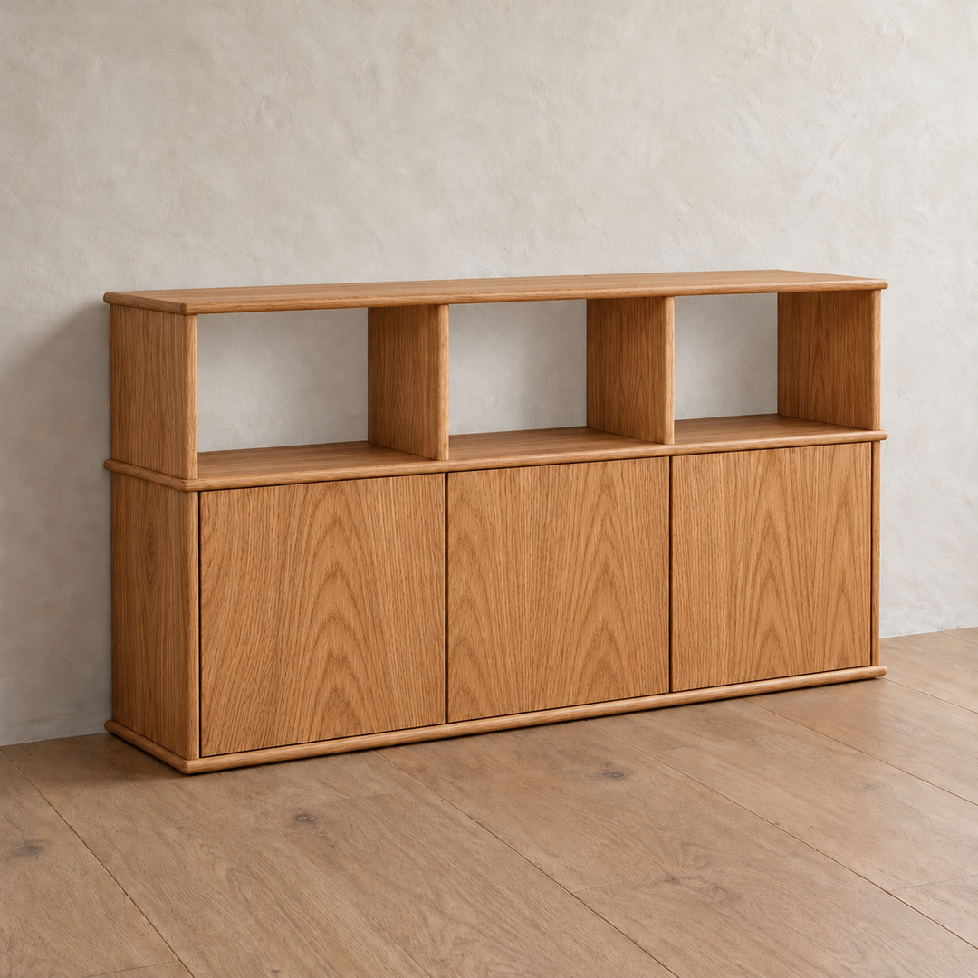 The three door sideboard in red oak from an angle, showing the softly rounded edges of its top and shelves.