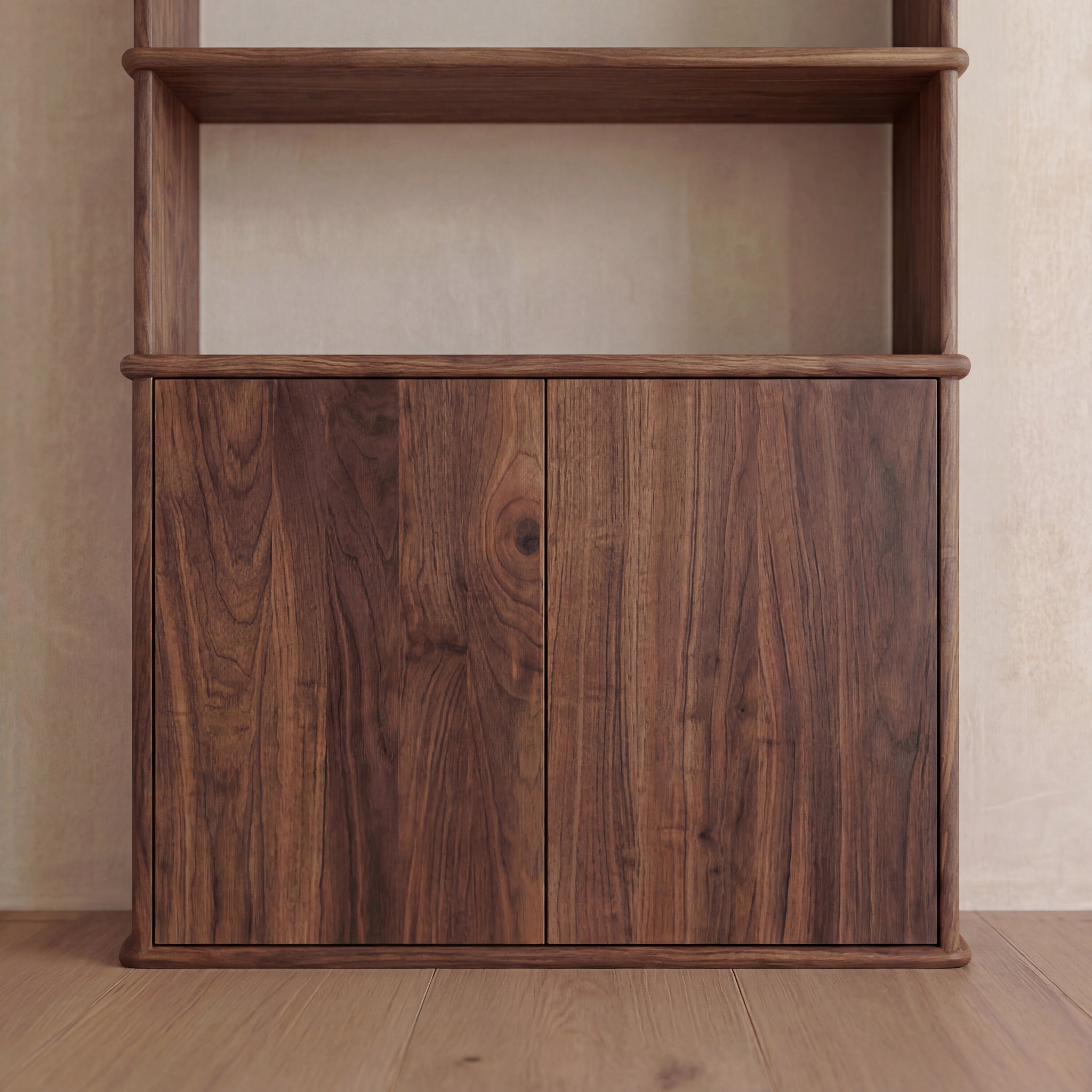 A close-up view of the lower section of the Cabinet bookshelf in walnut features two closed, push-to-open doors that highlight the natural wood grain. The unit is positioned on a light wooden floor against a beige wall.